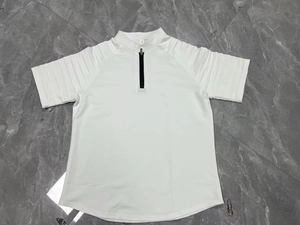 Detail view of the white polo shirt with quarter zip collar and pleated sleeves