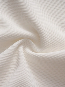 Close-up of premium white waffle weave fabric texture with breathable honeycomb pattern