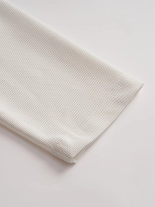 Close-up detail of white waffle knit fabric with professional honeycomb texture