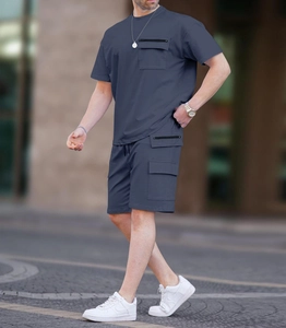 Completo techwear da uomo con t-shirt multitasche e pantaloncini cargo in un set all'aperto