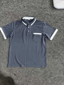 Detail view of a grey short sleeve Polo shirt with white contrast collar and chest pocket
