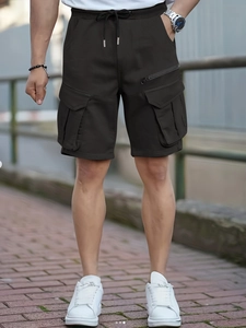 Detailed view of elastic drawstring waist and large cargo pockets on men's outdoor shorts