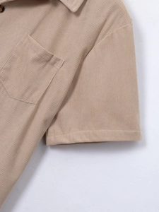 Detailed macro view of beige corduroy fabric texture and tortoiseshell buttons on shirt