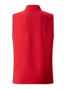 Rear view of bright red sleeveless top featuring textured vertical pleats and a stand collar