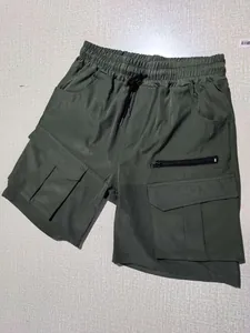 Detail view of army green cargo shorts with elastic waist and tactical side pockets