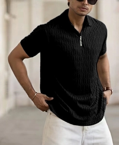Gros plan sur un polo noir pour homme avec tissu texturé et fermeture éclair argentée