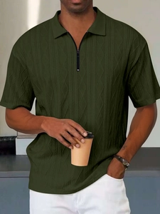 Dettaglio polo in maglia verde scuro con colletto a zip e texture jacquard uomo