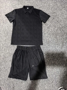 Detail of men's black polo set featuring unique waffle knit diamond textured fabric pattern