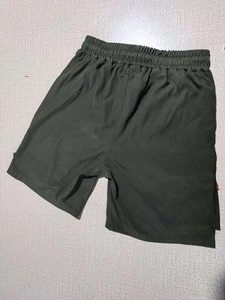 Detail view of olive green cargo shorts featuring an elastic drawstring waistband and pockets