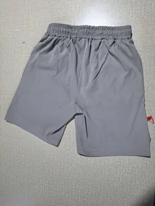 Detail of grey athletic shorts showing wide elastic waistband and quick-dry fabric texture