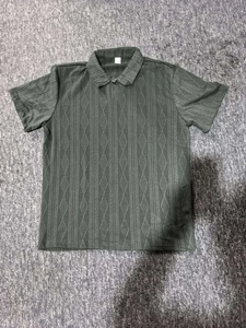 Gros plan d'un polo en maille vert foncé avec un motif géométrique texturé en losanges
