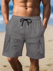 Detail of grey cargo shorts with elastic drawstring waist and functional large side pockets