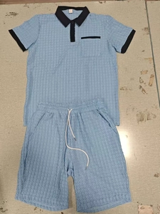 Detailed flat lay of light blue waffle knit men's polo set with black contrast trim