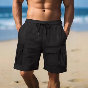 Men's black cargo shorts with elastic drawstring waist and side flap pockets on the beach