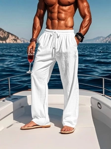 Close-up of men's white linen drawstring trousers shown on a yacht during vacation