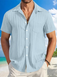 Detail of light blue linen striped shirt texture with chest pocket on beach background