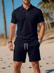 Schwarzes Herren-Poloshirt und Shorts-Set für den Sommer, am Strand präsentiert