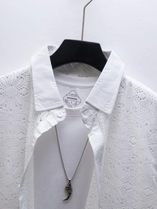 Détail de la chemise blanche pour hommes avec motifs ajourés en dentelle et col à revers