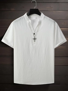 Close-up of white cotton short sleeve shirt with mandarin collar and cross necklace detail