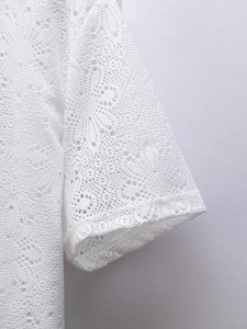 Gros plan sur un tissu en dentelle ajourée blanche aux motifs floraux géométriques