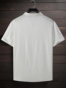 Detail view of the white cotton fabric texture on a men's stand collar short sleeve shirt