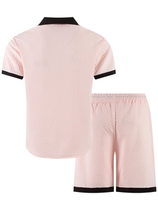 Detail view of pink men's knit set featuring geometric jacquard texture and black contrast edges