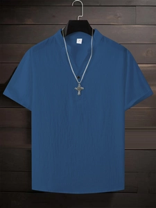 Detail of navy cotton shirt featuring V-neckline texture and silver cross necklace