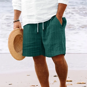 Detail of dark green striped casual shorts with elastic drawstring waist on beach