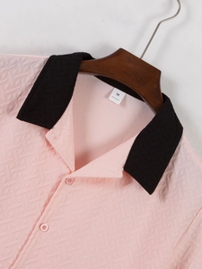 Detail of pink men's textured knit shirt with contrast black collar and size M label