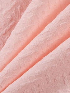 Detail shot of light pink jacquard fabric with raised texture for summer men's sets