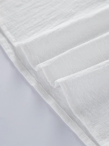 Close-up detail of white cotton linen fabric texture and stitching on men's shirt