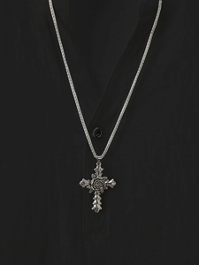Close-up of gothic silver cross necklace with detailed rose pendant on black shirt