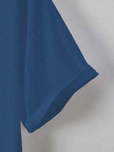 Detailed close-up of dark blue shirt sleeve with casual rolled cuff and linen texture