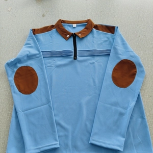 Detail of light blue polo shirt with brown elbow patches and textured knit fabric