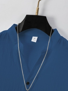 Detail of navy blue cotton shirt showing mandarin collar, black buttons and fabric texture
