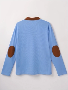 Close-up of blue polo shirt with brown elbow patches and waffle knit fabric texture