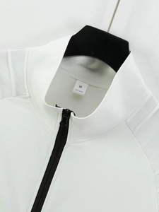 Close-up of white jacket collar with black zipper and 100% polyester size M label