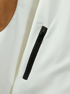 Detail shot of a white sports jacket featuring a vertical black zipper and brown circular trim