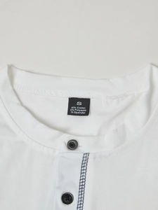 Detail of white Henley shirt neckline with buttons and fabric care label showing S size