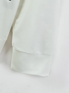 Detail shot of the white jacket sleeve cuff featuring dense knit fabric and clean stitching
