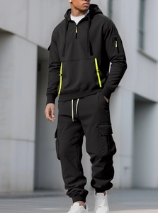 Detail of men's black fleece hoodie and cargo pants set with neon yellow pocket accents