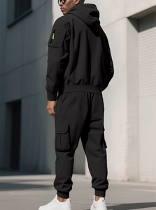 Close-up of black hoodie sleeve with yellow zipper detail and cargo pants back view