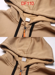Detail view of the collar size label and 100% polyester care tag on the brown hoodie