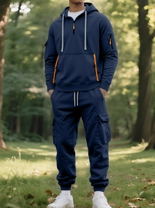 Detail of navy blue hooded tracksuit with orange zipper accents and cargo style side pockets