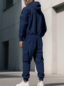 Detail of navy blue hoodie with orange arm pocket and matching side pocket cargo pants