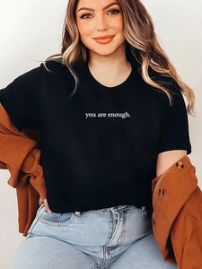 Detail des weißen 'you are enough' Aufdrucks auf schwarzem Baumwoll-T-Shirt mit Jacke