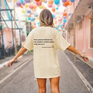 Detail des inspirierenden Textdrucks auf der Rückseite des cremefarbenen T-Shirts