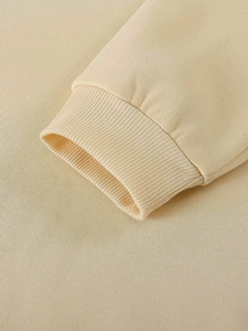 Dettaglio dei polsini a costine beige con cuciture di qualità su una felpa in pile