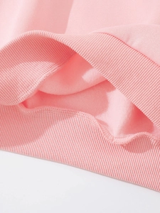 Dettaglio macro della felpa rosa con orlo a costine e morbida fodera in pile