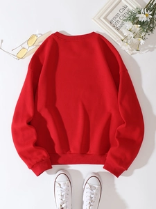 Flat lay di una felpa rossa a girocollo in pile con accessori moda e decorazioni casual